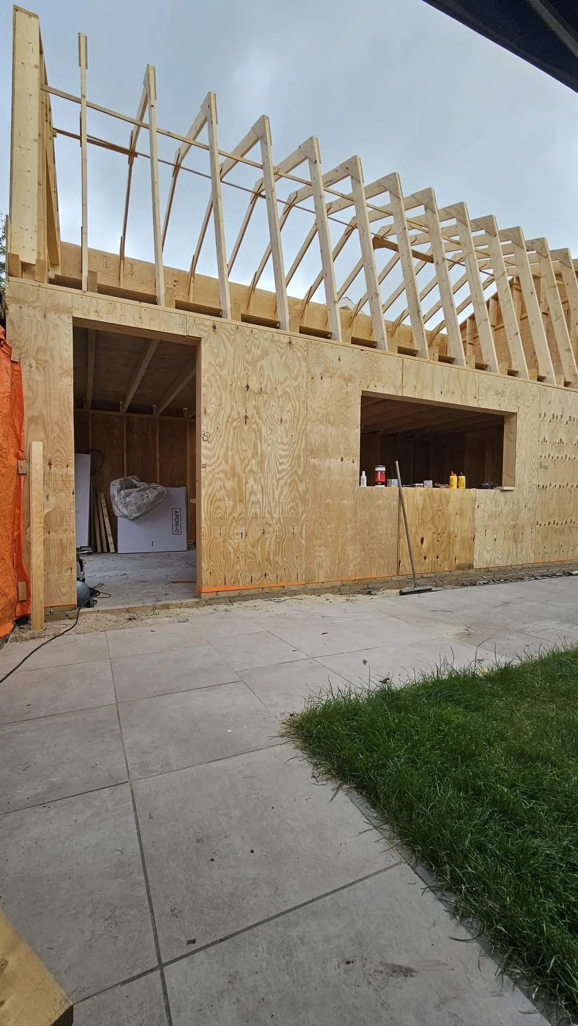 Nieuwe houten spanten opgesteld boven een woning in aanbouw