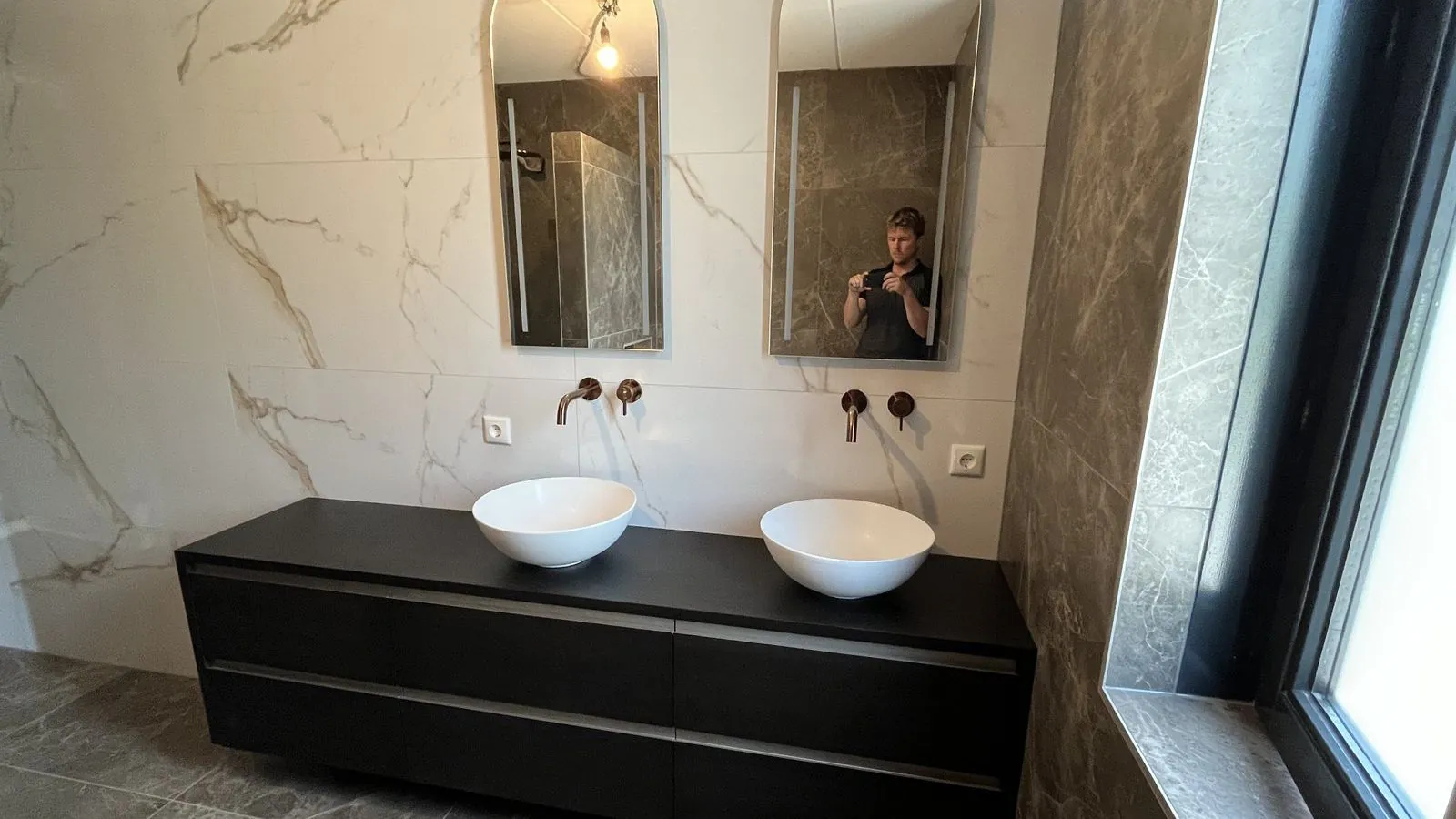 Badkamer met grootformaat tegelwerk in marmerlook