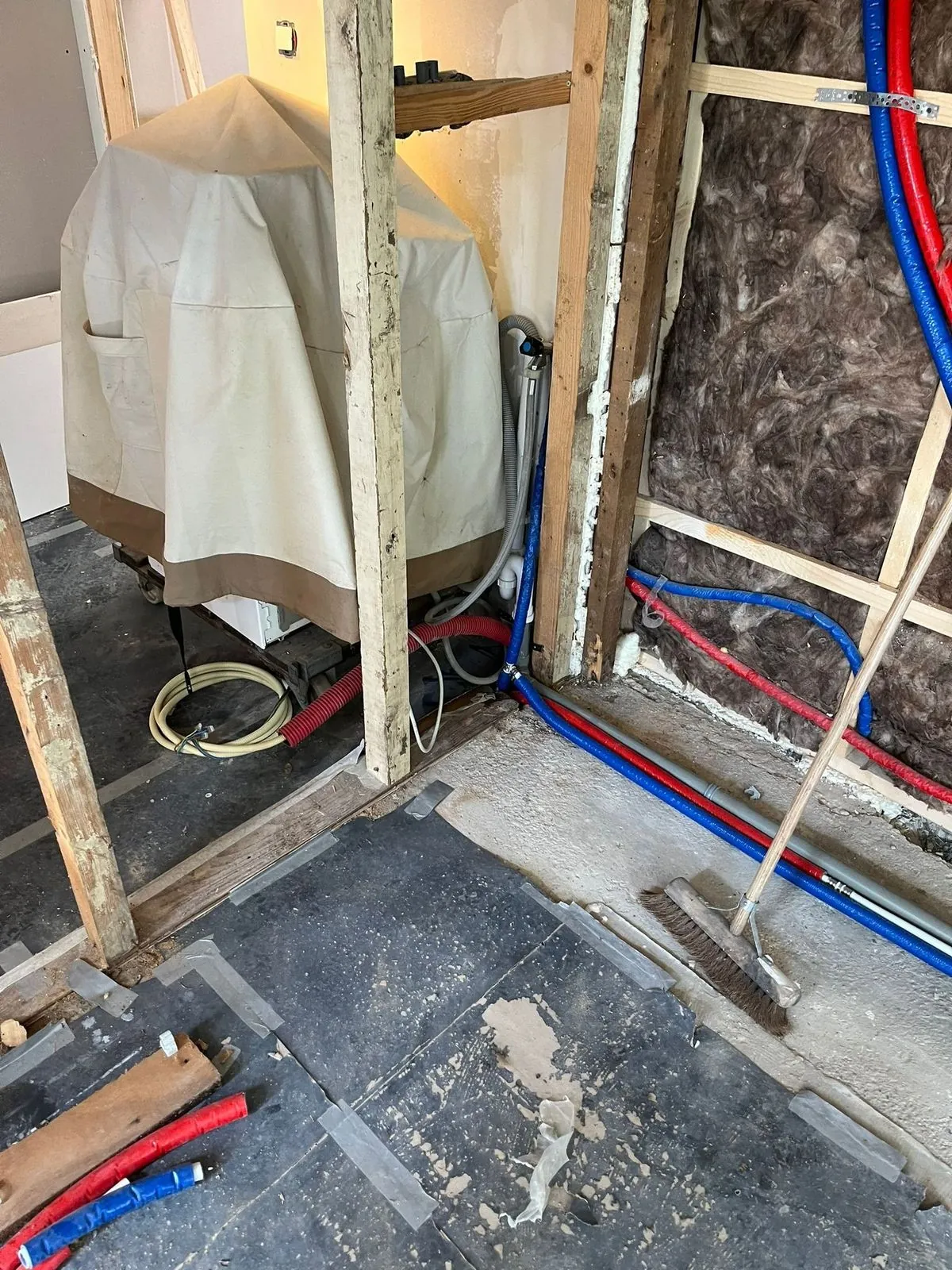 Badkamer in de ruwbouwfase met leidingwerk en kale wanden