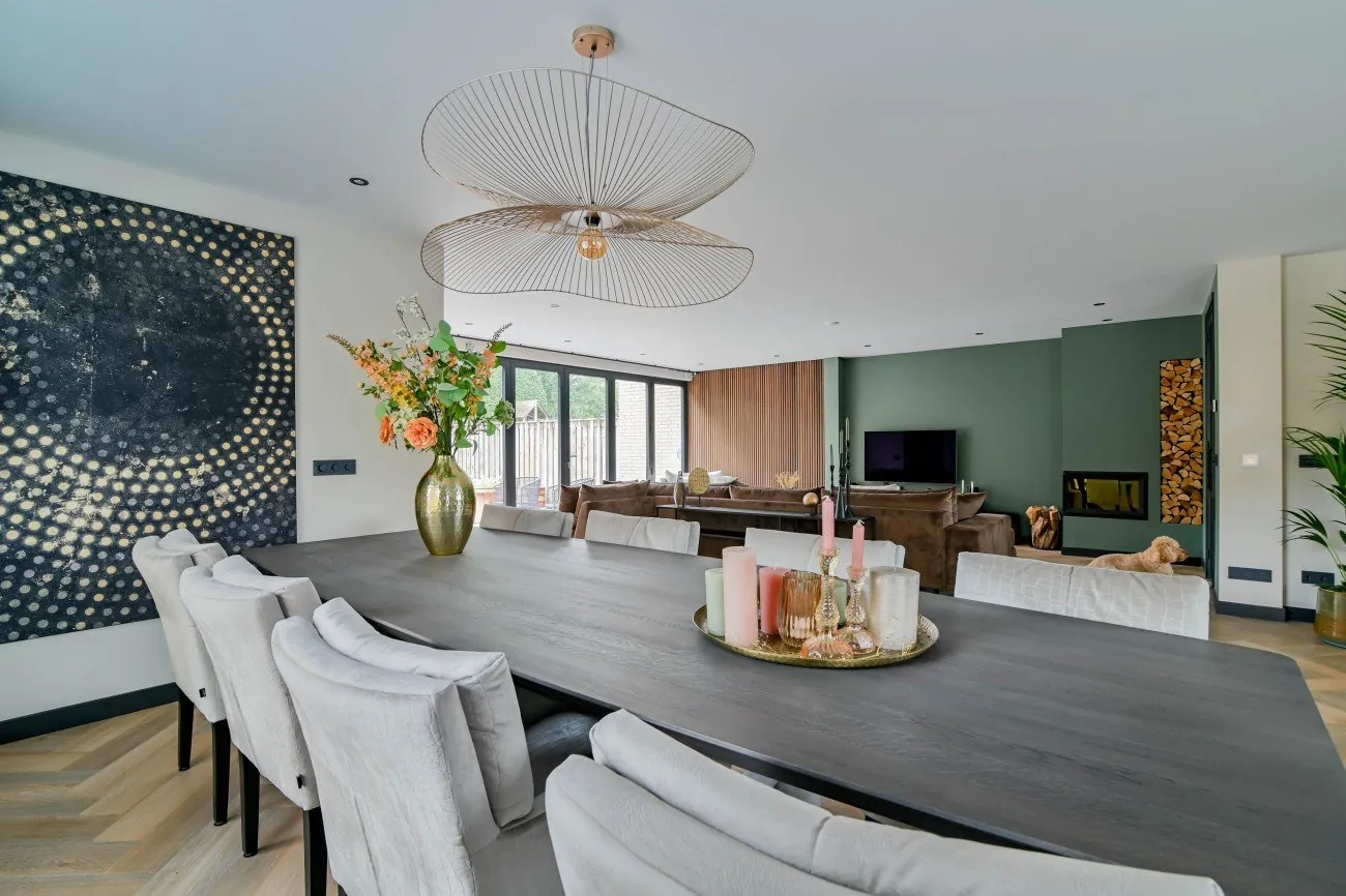 Open woonkeuken met eettafel en haard na een totaalrenovatie door Strooper Bouw