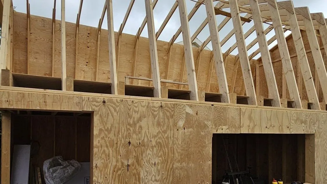 Kapconstructie van een aanbouw in aanbouw, met houten spanten op een plaatwand