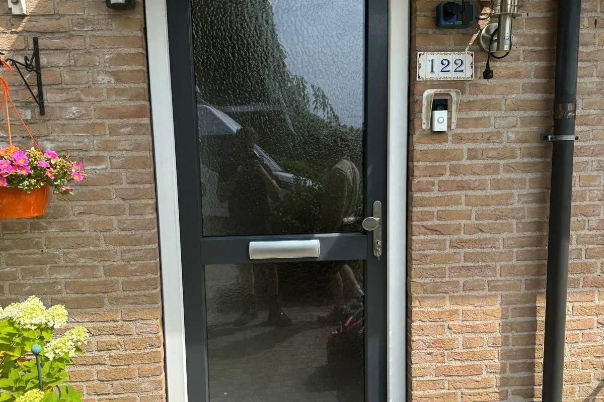 Voordeur met zijlicht in een donker kozijn