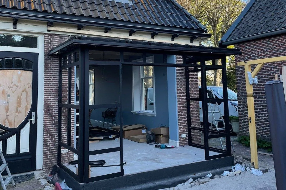 Veranda met stalen constructie en een glazen dak boven het terras